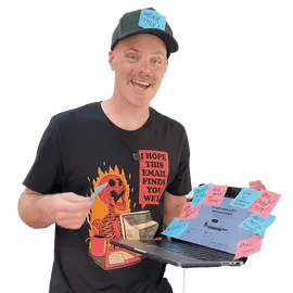 Person holding a laptop covered in sticky notes, in a t-shirt reading I hope this email finds you well