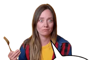 Person holding a wooden spatula, raising an eyebrow