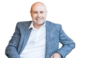 Person in a grey blazer, smiling